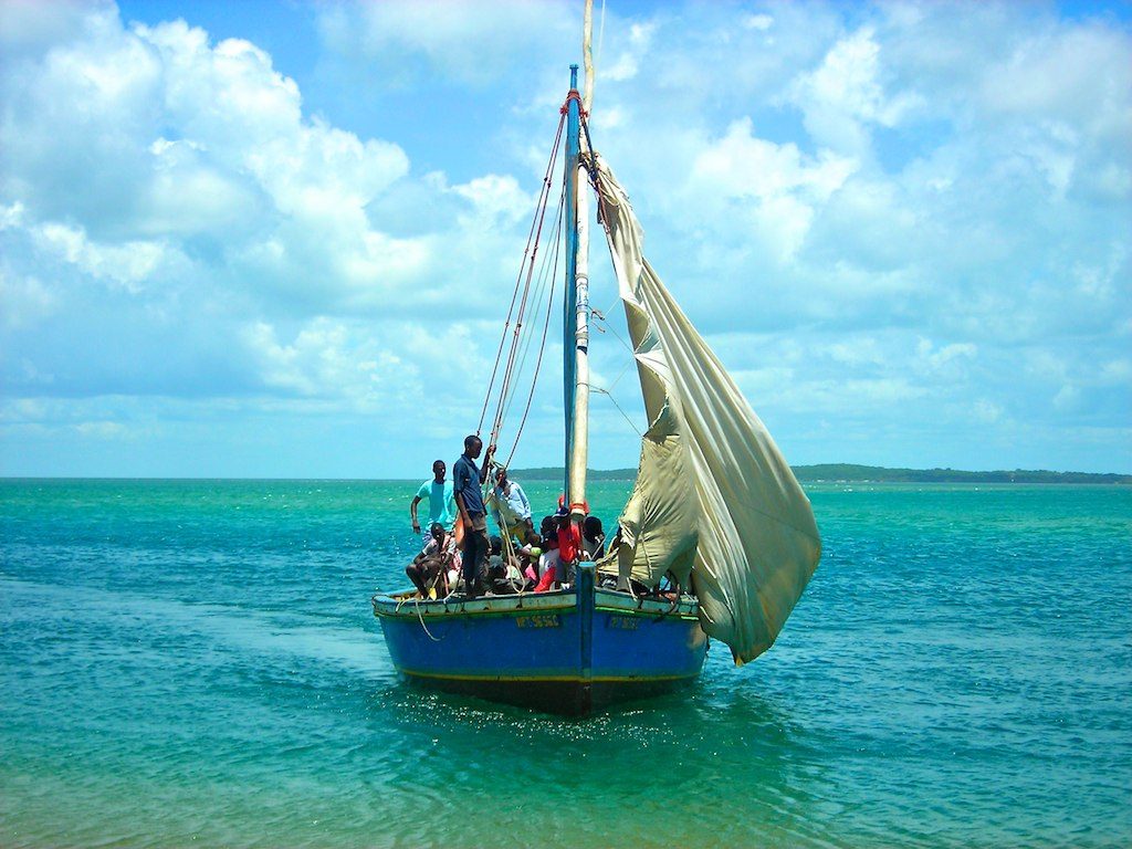 Mozambique boat with locals in floating on turquoise waters